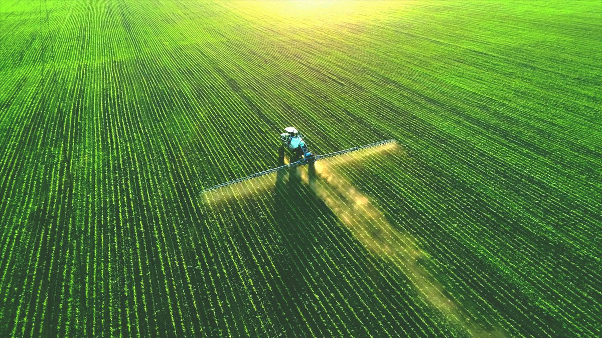 Tractor,Spray,Fertilizer,On,Green,Field,Drone,High,Angle,View,