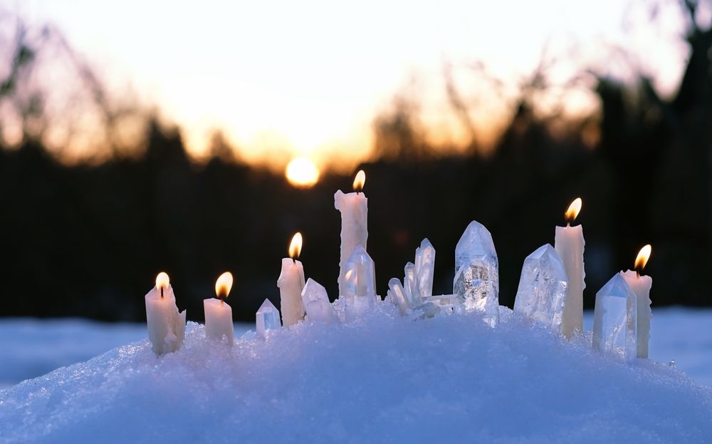 Quartz,Minerals,And,Burning,Candles,On,Snow,,Natural,Winter,Background.