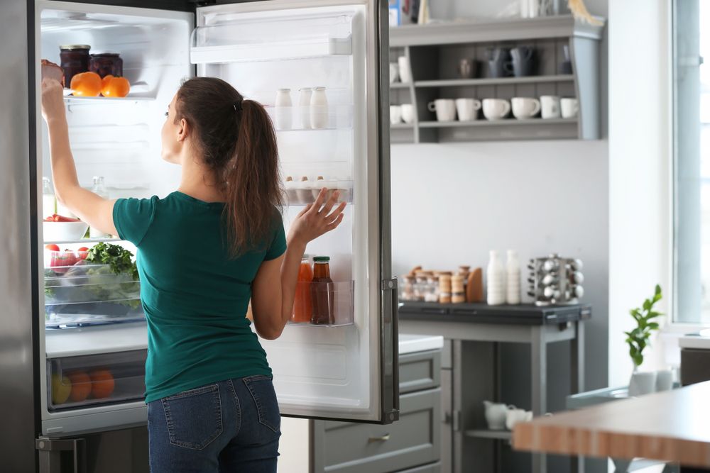 Woman,Taking,Food,Out,Of,Fridge,At,Home