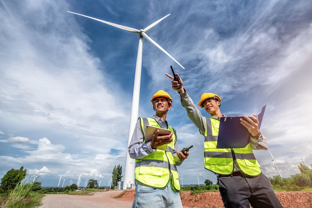 Two,Asian,Male,Engineers,Working,On,Site,With,Wind,Turbine