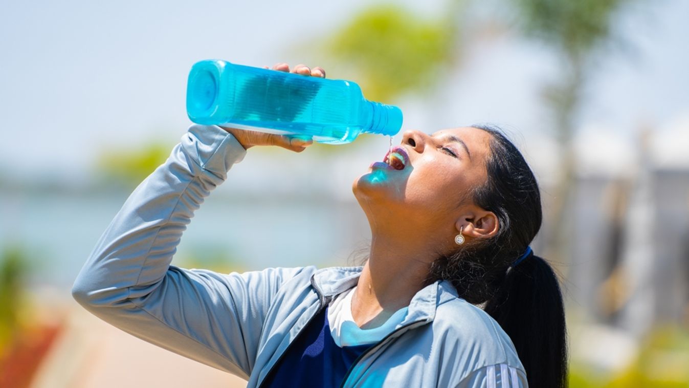 Thirsty,Woman,Drinking,Water,From,Bottle,After,Workout,At,Park