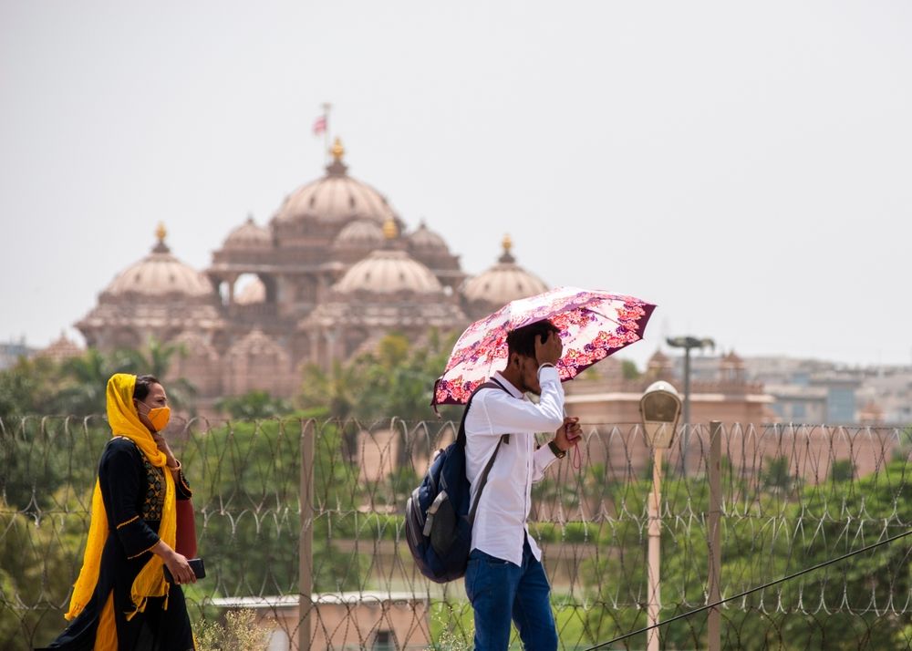 New,Delhi,,India-,May,9,2022:,Man,With,Umbrella,Crossing