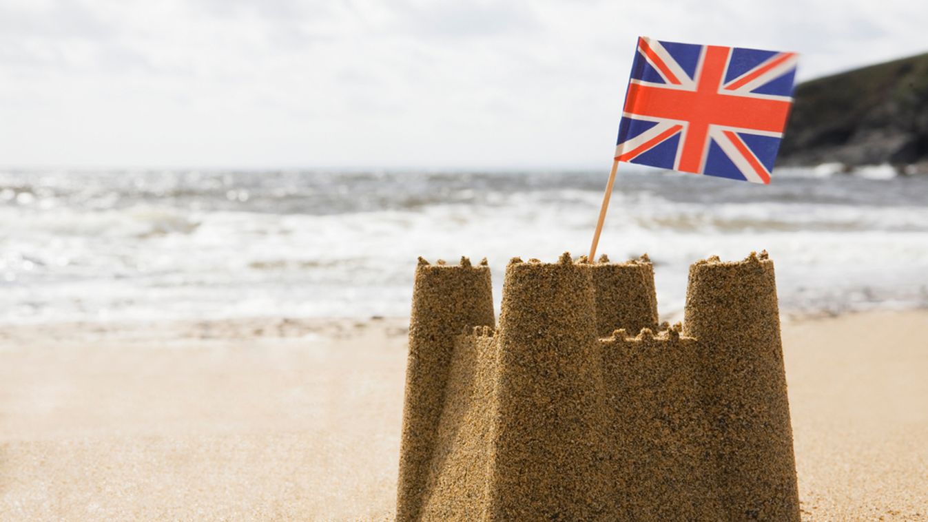 Sandcastle,On,Empty,British,Beach,With,Uk,Union,Jack,Flag