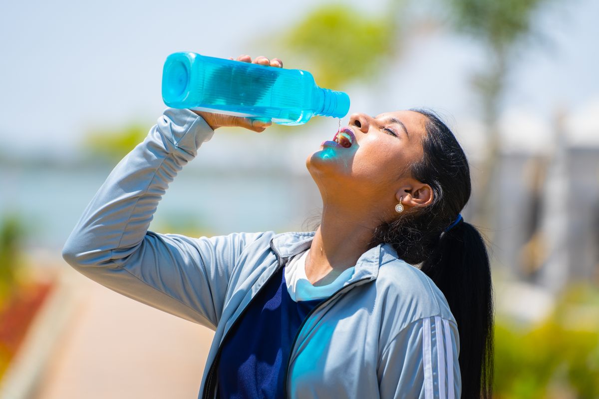 Thirsty,Woman,Drinking,Water,From,Bottle,After,Workout,At,Park