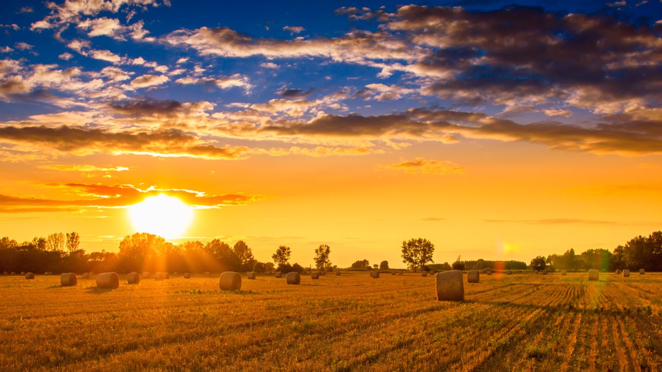 End,Of,Day,Over,Field,With,Hay,Bale,In,Hungary-