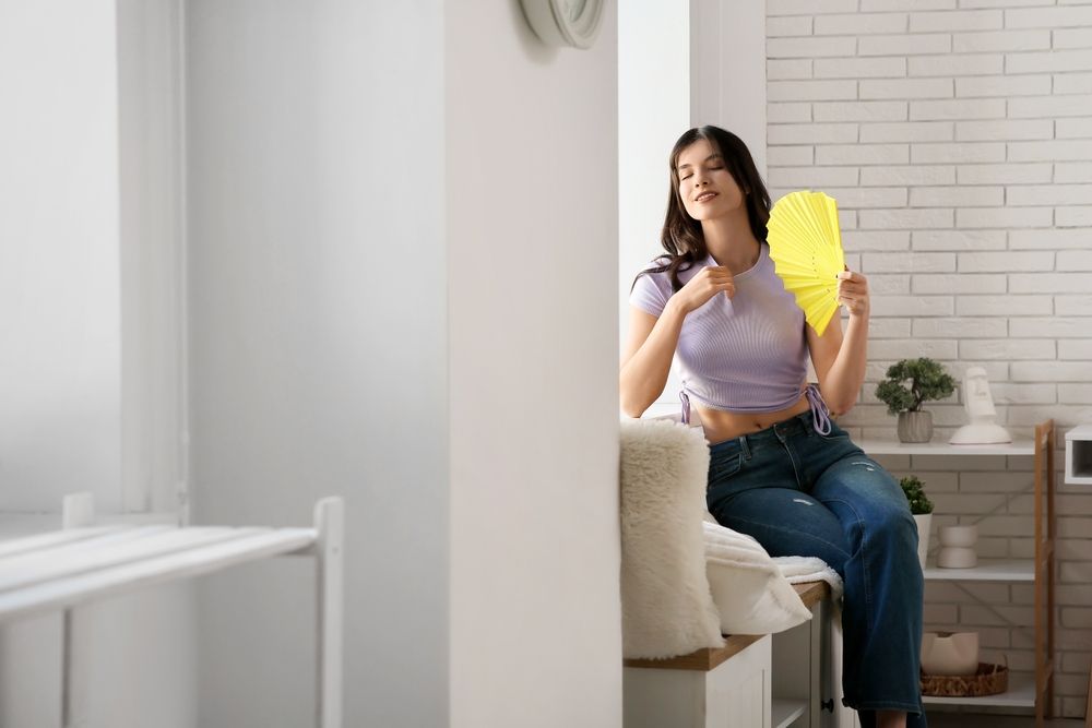 Young,Pretty,Woman,With,Hand,Fan,Near,Window,In,Room