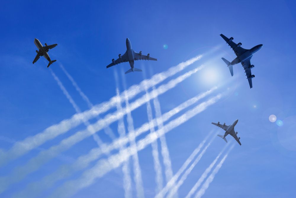 Airplanes,Fly,Against,A,Blue,Sky,,Leaving,Contrails