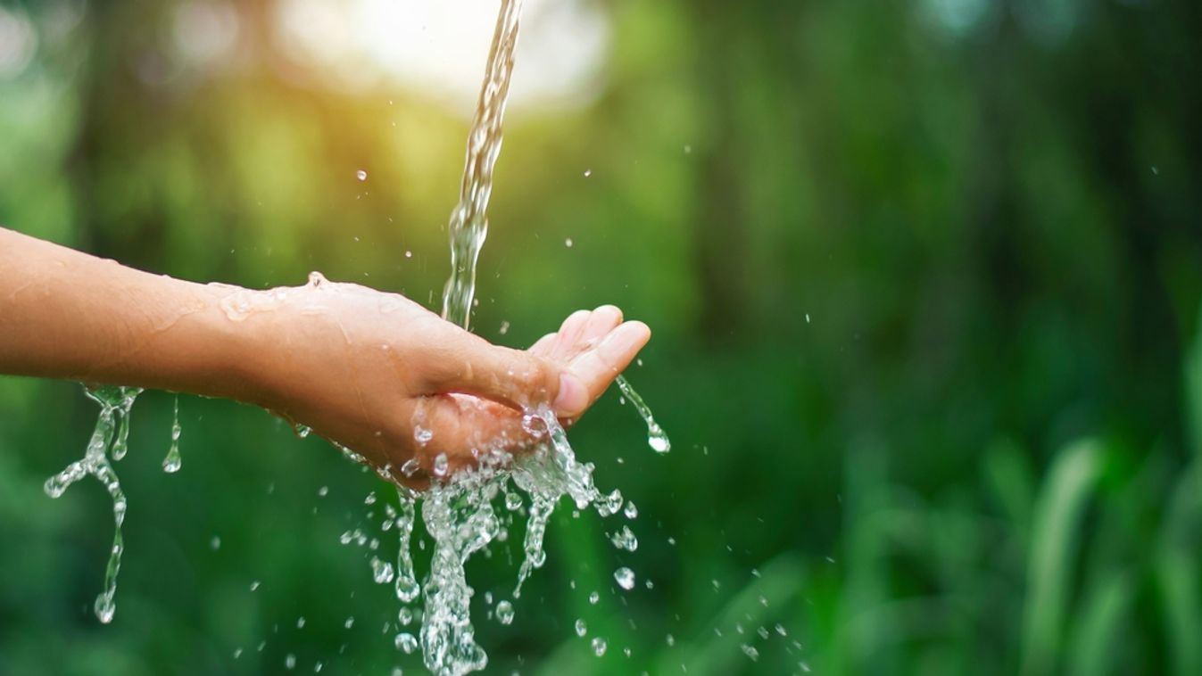 Water,Pouring,Flow,On,Woman,Hand,On,Nature,Background