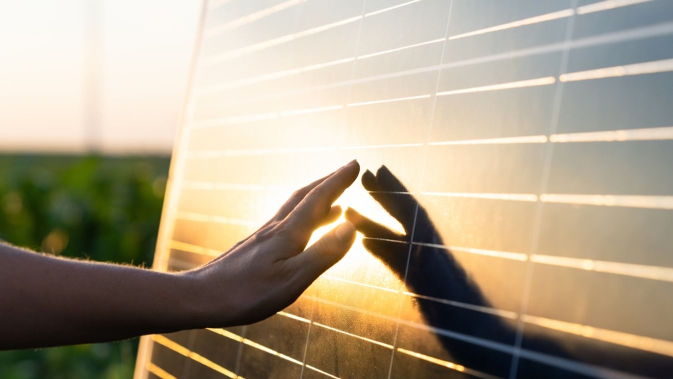 Close-up,Of,A,Hand,Touching,A,Solar,Panel,At,Sunset.