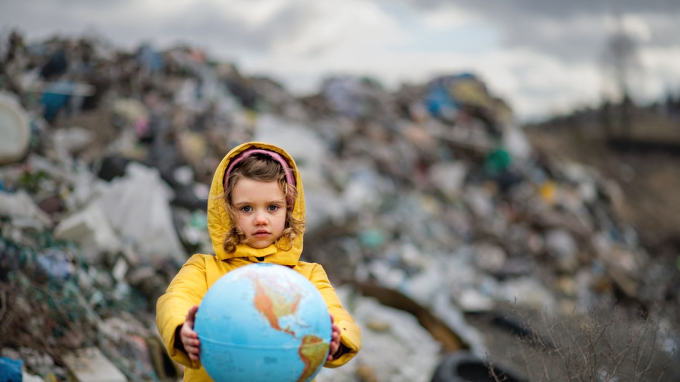 Small,Child,Holding,Globe,On,Landfill,,Environmental,Pollution,Concept.