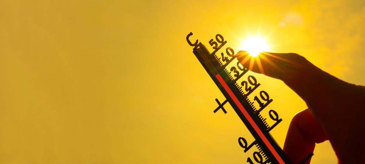 kánikula, hőmérőt tartó kéz napsütésben